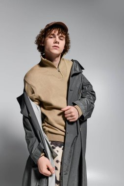 Genç, şık iç mekanlarda şık kıyafetler giyerken kendine güvenen pozlar sergiliyor.