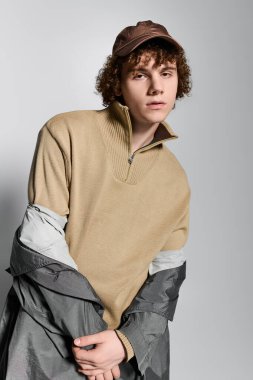 Gençler eşsiz bir stil sergiliyor, modern elementleri basit bir arkaplan karşısında serin bir pozda harmanlıyorlar..