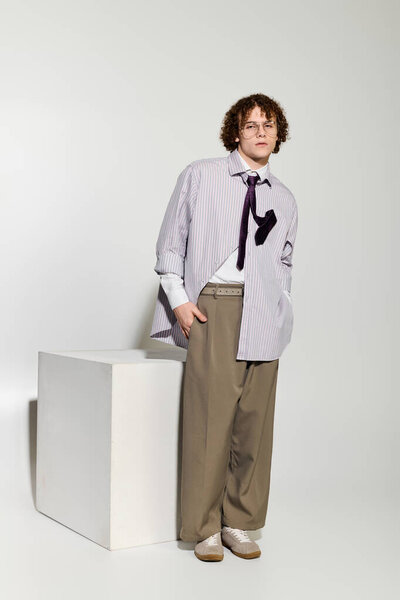 Teenager showcases trendy outfit with relaxed confidence, highlighting unique style and personality.