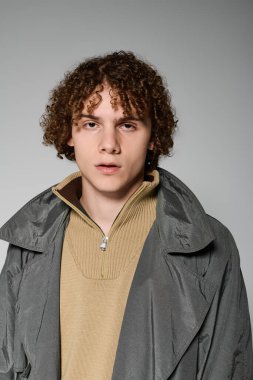 Gençler, gençlik enerjisi ve stili yayarak, basit gri bir arkaplana karşı keskin bir şekilde poz verirler..