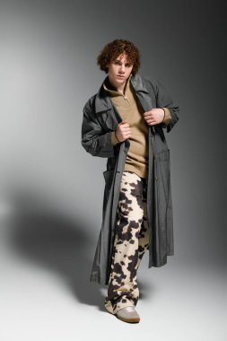 Genç, kendine güvenen bir şekilde göz alıcı bir şekilde poz veriyor, modern stili sanatsal yeteneklerle harmanlıyor..