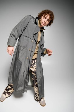 Moda kıyafetli enerjik genç, minimalist bir geçmişe karşı cesur bir poz verdi.