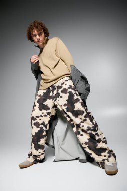 Genç dinamik bir poz verirken aynı zamanda modaya uygun kıyafetler ve kumaşlar sergiliyor..