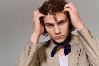 Genç, dinamik bir duruş sergilerken kendine güveni tam, kişisel stili ve yeteneği ön plana çıkarıyor..