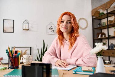 Kızıl saçlı genç bir kadın şık, rahat dairesinde rahatlıyor, sıcaklık saçıyor..