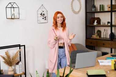 Parlak kızıl saçlı genç bir kadın evinde rahat bir anın tadını çıkarıyor, kış için şık giyinmiş..