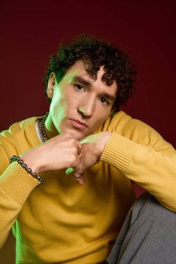 Sarı kazaklı yakışıklı adam, kendine güvenen, çağdaş moda ve tarz saçan biri..