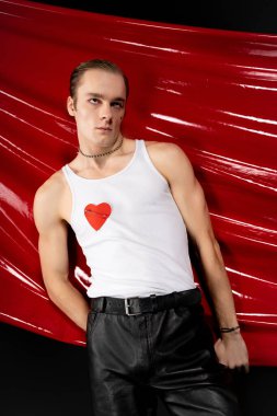 Kendinden emin bir adam, sevgililer gününde, cesur renklerle çevrili, neşe ve gurur ifade eder..