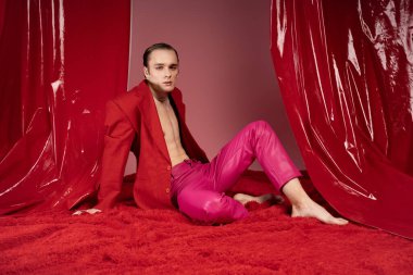 Şık bir adam kendine güven ve neşe saçar canlı pembe ve kırmızı giysiler içinde, sevgiyi kucaklayan ruh..