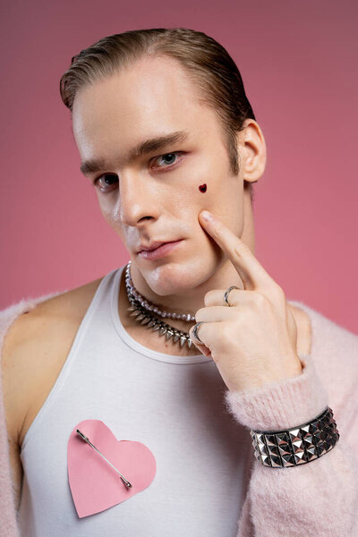 A stylish man proudly showcases his identity and joy on Valentine Day with playful accessories.