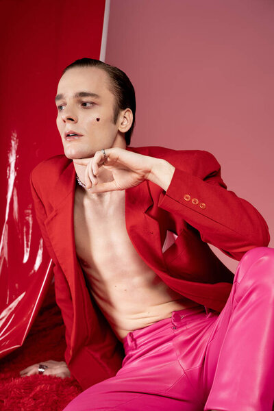 Уверенный в себе человек демонстрирует свою уникальную моду в ярко-красном и розовом, отмечая любовь и гордость.