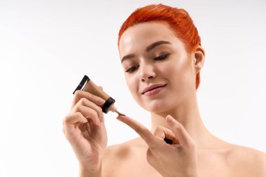 Kızıl saçlı genç kadın makyaj yapıyor, yeteneklerini sergiliyor..