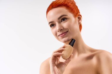 Şık bir kadın makyaj malzemeleri şişesini tutarken gülümsüyor, güzellik ve zarafet saçıyor..