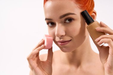 Güzel bir kadın makyaj yeteneklerini güzellik karıştırıcısı ve temeli kullanarak sergiliyor..