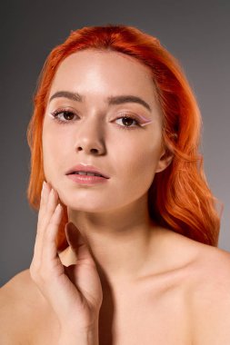 Güzel bir kadın kendine güvenerek poz veriyor, eşsiz makyajını ve çarpıcı özelliklerini vurguluyor..