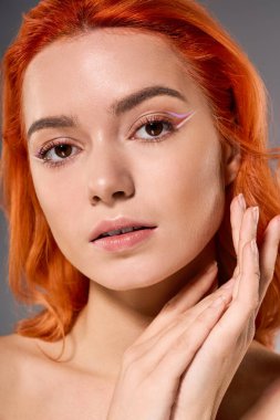 Genç bir kadın, eşsiz stilini ve makyajını yaratıcı bir mekanda sergiliyor. Kendine güveni tam..