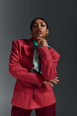 Genç siyahi bir kadın kendine güvenerek modaya uygun bir şekilde poz veriyor ve benzersiz tarzını sergiliyor..