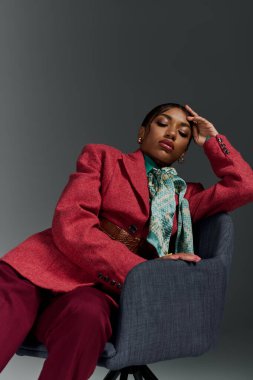Genç bir Afrikalı Amerikalı kadın şık bir kıyafetle rahatlıyor, moda anlayışını sergiliyor..