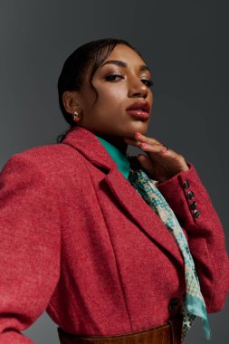 Genç bir Afrikalı Amerikalı kadın stüdyo ortamında şık kıyafetler sergiliyor..