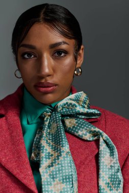 Genç bir Afrikalı Amerikalı kadın, bir stüdyoda kendine güvenen şık kıyafetler sergiliyor..