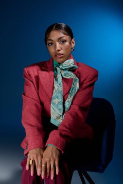 Genç bir Afrikalı Amerikalı kadın şık kıyafetlerini canlı bir stüdyoda sergiliyor..