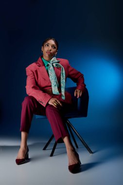 Kendine güvenen genç siyahi bir kadın sanatsal stüdyo ışıklarında şık bir şekilde poz veriyor..