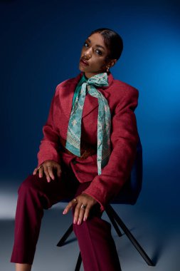 Genç bir Afrikalı Amerikalı kadın şık ve şık kıyafetlerini canlı bir stüdyoda sergiliyor..