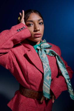 Genç bir kadın şık kıyafetlerini canlı bir stüdyoda sergiliyor, büyüleyici bir şekilde..