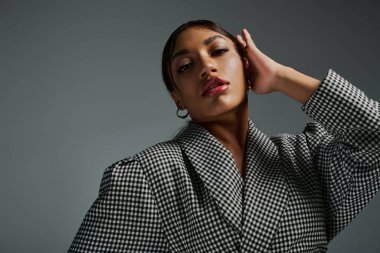 Genç bir Afrikalı Amerikalı kadın şık bir stüdyoda moda anlayışını sergiliyor..