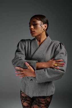 Genç siyahi bir kadın şık, şık, şık görünümünü moda bir stüdyoda sergiliyor..