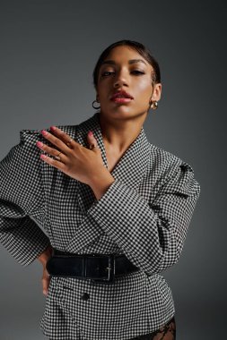 Kendine güvenen genç bir Afrikalı Amerikalı kadın moda kıyafetleriyle poz veriyor, kendi tarzıyla dikkat çekiyor..