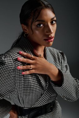 Genç bir Afrikalı Amerikalı kadın modaya uygun bir kıyafetle poz veriyor, tarz ve zarafet saçıyor..