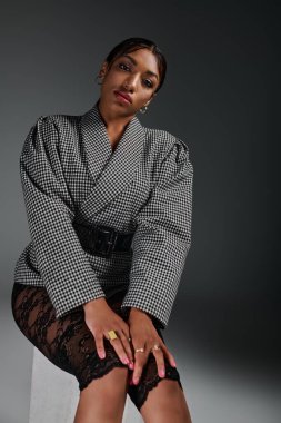 Genç bir Afrikalı Amerikalı kadın modern bir stüdyoda şık ve şık giyiniyor..