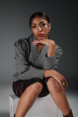 Stüdyoda kendine güvenen genç bir kadın zarif bir şekilde poz verir..