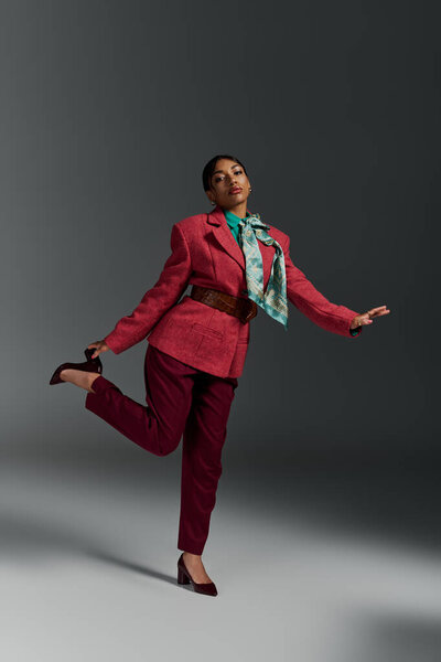 A confident young woman poses in a stylish outfit, showcasing her unique fashion sense in a studio.