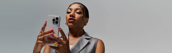 Молодая афроамериканка, одетая в моду, исследует свой смартфон в очаровательной студии, баннер