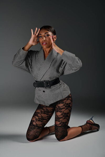 Молодая женщина демонстрирует свое потрясающее чувство стиля с элегантностью и уравновешенностью в студии.