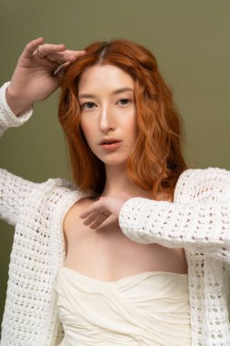 Kızıl saçlı bir kadın moda anlayışını bahar aylarında bir stüdyoda sergiliyor. Gençlik ve güzellik saçıyor..