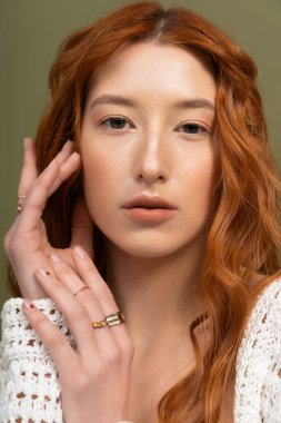 Güzel, genç, kızıl saçlı bir kadın zarif bir bahar modasıyla poz veriyor, tarzını sergiliyor..