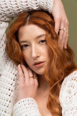 Güzel bir kızıl saçlı, zarif bir şekilde stüdyoda poz verir, moda bahar kıyafetleri giyer..