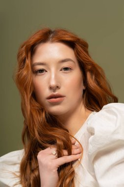 Genç bir kadın, bir stüdyoda poz vererek canlı bahar kıyafetlerine güzellik ve güven yayar..