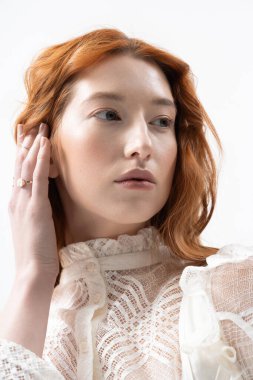 Kızıl saçlı güzel bir kadın bahar modası için şık bir stüdyoda zarif poz veriyor..