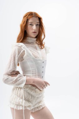 Genç bir kızıl zarif bir kıyafetle poz veriyor. Stüdyoda bahar tarzını somutlaştırıyor..