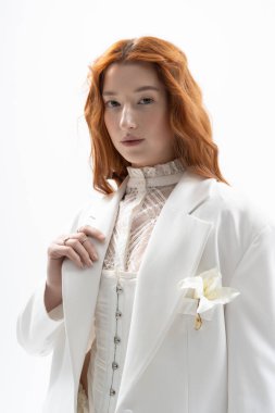 Hoş, genç bir kızıl şık bir elbiseyle poz veriyor, bahar modasını gösteriyor..