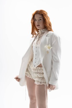 Şık giyinmiş genç bir kadın minimalist bir stüdyoda zarif poz veriyor..