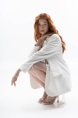 Şık giyinmiş genç bir kızıl kadın poz verirken bahar ruhunu yakalıyor..