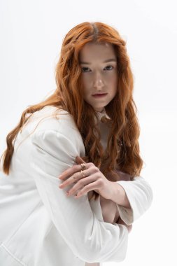 Muhteşem kızıl saçlı genç bir kadın zarif bir poz veriyor, bahar havası veriyor..