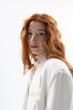 Güzel bir kızıl saçlı, bahar modasının özünü somutlaştıran bir stüdyoda şık poz veriyor..