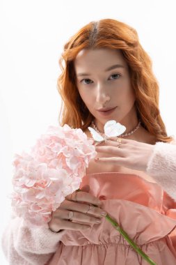 Genç bir kızıl saçlı şık bir bahar elbisesi, narin çiçekler ve ışıl ışıl bir güzellik taşıyor..