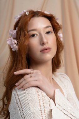 Uçan kızıl saçlı genç bir kadın çiçek stüdyosunda bahar modasına giriyor..